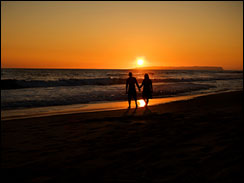 Couple walks along a beach in Hawaii