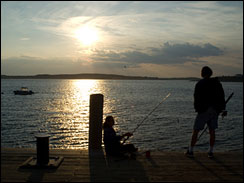 Mother fishing while her child is standing